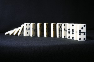 Dominoes falling from back on black background