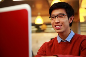 Smiling man typing on laptop