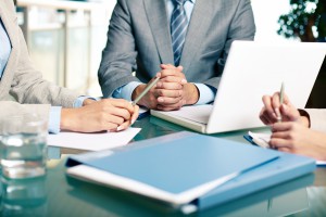 Close-up of hands of boss at workplace with laptop and hands of two females near by