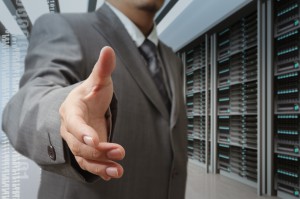 businessmen offer hand shake in a technology data center